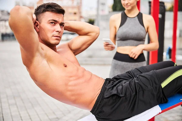 Musculoso guapo chico haciendo abdominales crujidos al aire libre — Foto de Stock