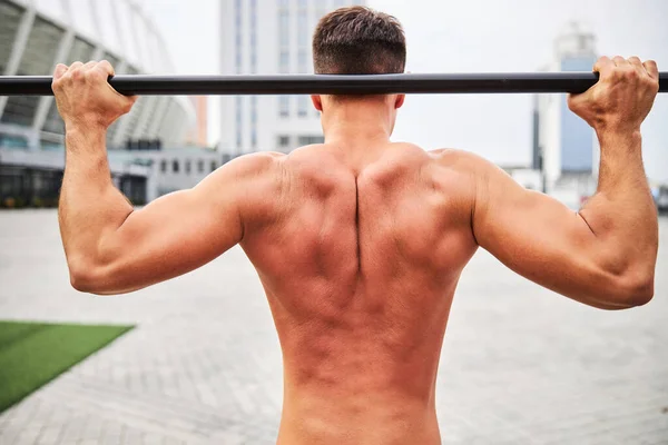 Fuerte hombre en topless ejercitando en el campo de deportes urbanos — Foto de Stock