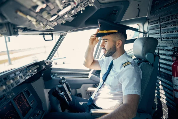 Mężczyzna pilot w mundurze czeka na latającym samolocie. — Zdjęcie stockowe