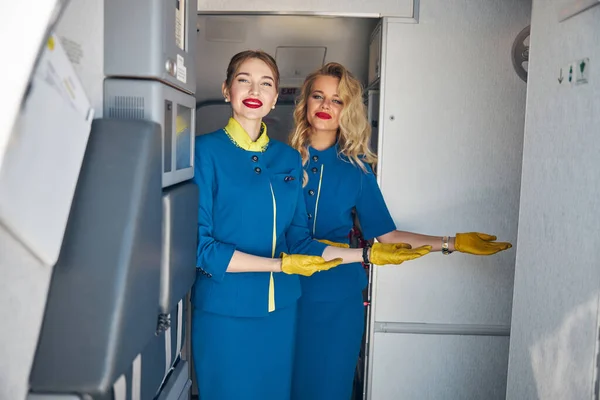 Feliz azafata sonriente invitando a bordo del avión — Foto de Stock