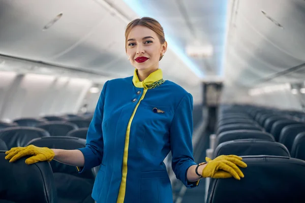 Feliz azafata sonriente llevando traje sonriendo a la cámara fotográfica — Foto de Stock