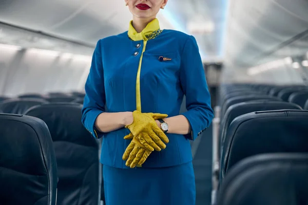 Симпатичная стюардесса в синем костюме в салоне самолета — стоковое фото