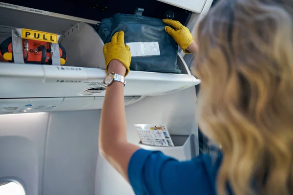 Hermosa azafata manteniendo el orden en el avión de pasajeros — Foto de Stock