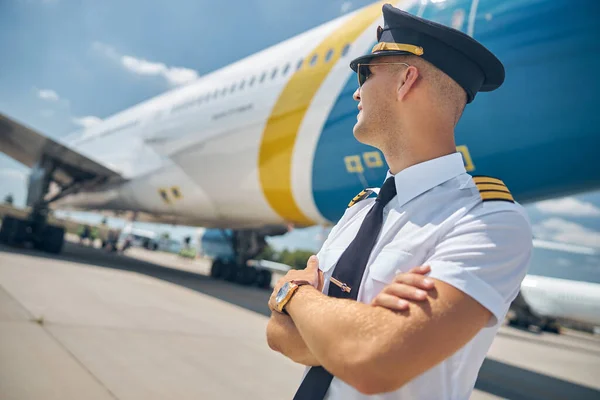 Bonito piloto masculino em pé de avião no aeródromo — Fotografia de Stock