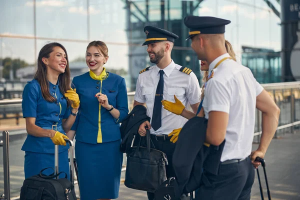 Alegres trabajadores de aerolíneas hablando en la calle — Foto de Stock