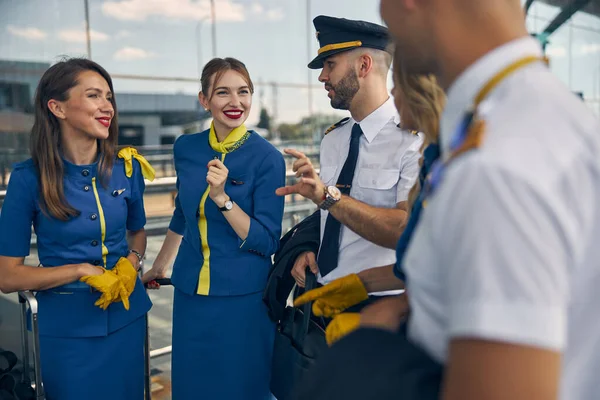 Vidám stewardess beszél pilóták az utcán — Stock Fotó