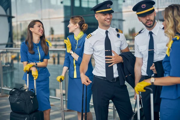 Veselí pracovníci aerolinií si povídají na ulici — Stock fotografie