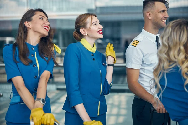 Cheerful stewardesses and pilots standing on the street — Stock Photo, Image