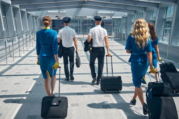 공항 터미널에서 여행 가방을 운반하는 비행기 승객들 — 스톡 사진