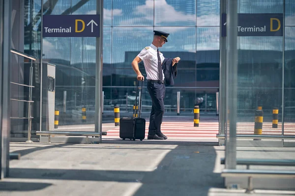 Boa aparência piloto masculino verificando o tempo no aeroporto — Fotografia de Stock