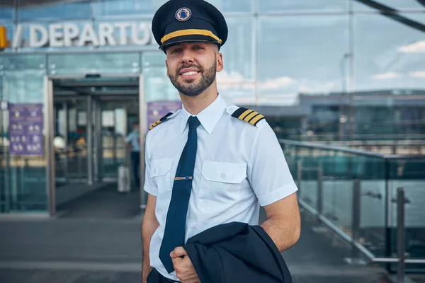 Handsome male pilot standing on the street