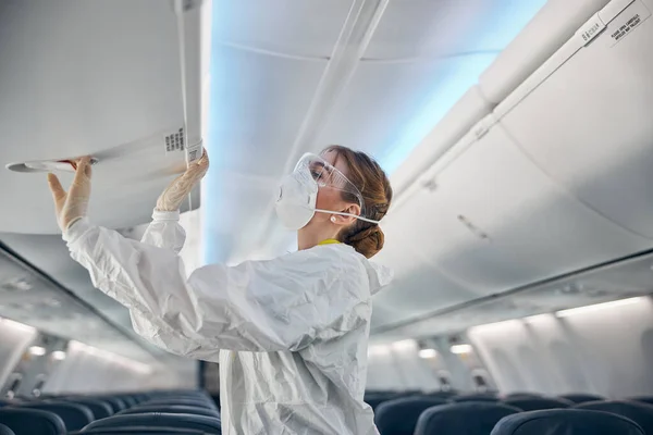 Azafata de aire hembra en compartimiento de cabina de cierre uniforme blanco — Foto de Stock