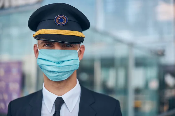 Capitão de avião em máscara médica em pé na rua — Fotografia de Stock