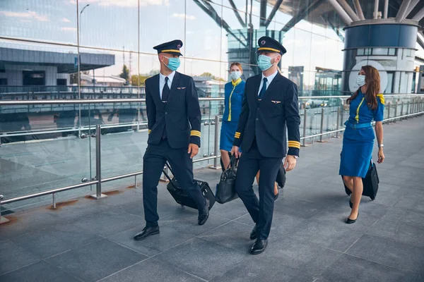 Aviones con máscaras médicas caminando por la calle — Foto de Stock