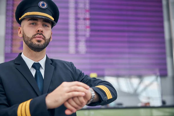 Handsome male pilot standing in airport terminal — Stock Photo, Image