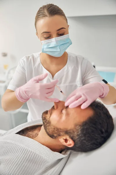 Orakad ung man får kosmetiska injektioner på wellness center — Stockfoto