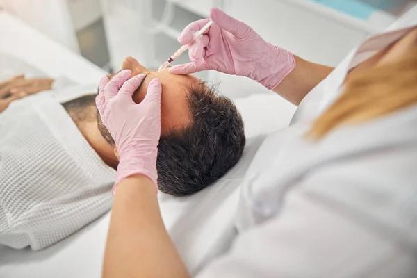 Giovane uomo che riceve iniezioni di cosmetici al centro benessere — Foto Stock