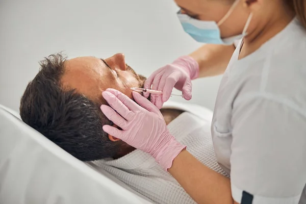 Estetista femminile che fa l'iniezione in faccia maschile — Foto Stock