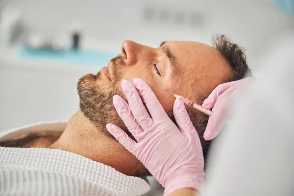 Handsome young man receiving cosmetic facial injections — Stock Photo, Image