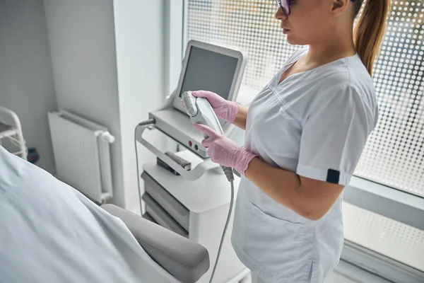 Charming female beautician holding IPL laser device — Stock Photo, Image