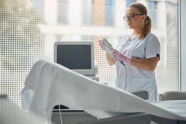 Cosmetologista feminino encantador usando dispositivo laser IPL — Fotografia de Stock