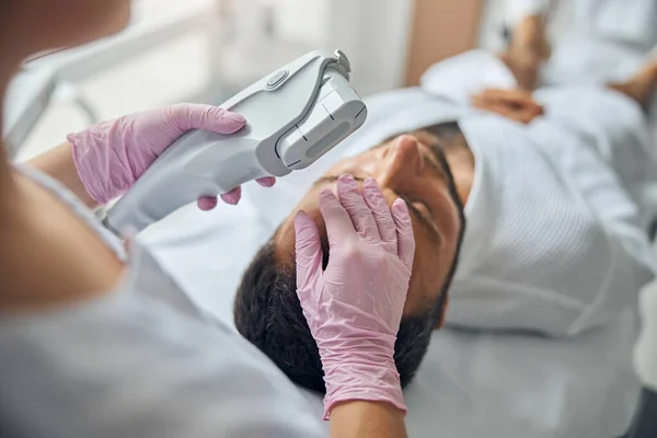 Junger Mann erhält Laser-Gesichtsbehandlung in kosmetologischer Klinik — Stockfoto