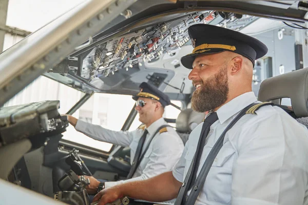 Contented experienced men navigating the aircraft and smiling — Stock Photo, Image