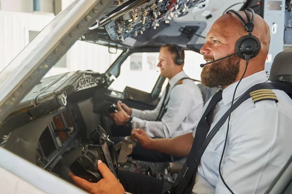 Zelfverzekerde piloten klaar voor de internationale vlucht in moderne vliegtuigen — Stockfoto
