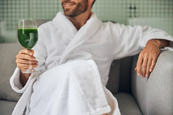 Joven barbudo bebiendo batido en el salón de spa — Foto de Stock