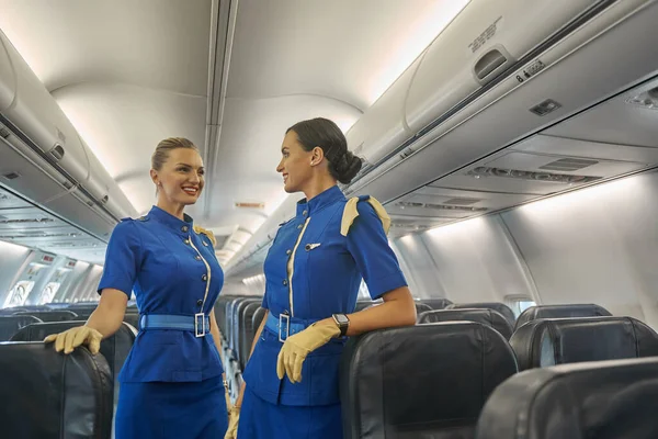 Két női légiutas-kísérő várja az utasokat. — Stock Fotó