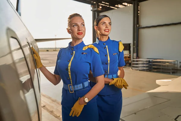 Beautiful air hostesses on sunny day at work looking happy — Stock Photo, Image