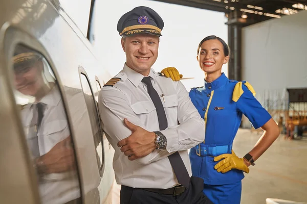 Щасливі працівники авіакомпанії стоять в ангарі — стокове фото