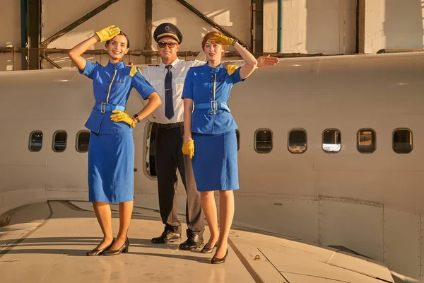Bonitas hospedeiras de voo posando com seu colega de trabalho — Fotografia de Stock