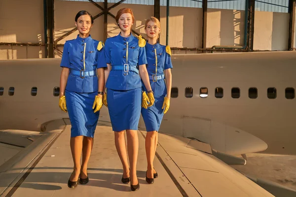 Tres bonitas azafatas sonriendo y caminando — Foto de Stock