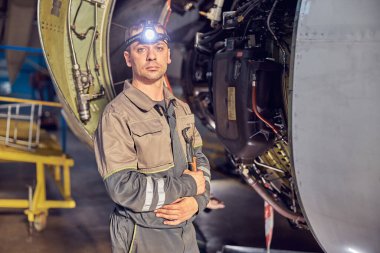 Havacılık hangarında jet türbinli bir adam var.