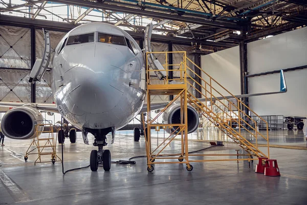 Airplane at parking apron in the aviation hangar