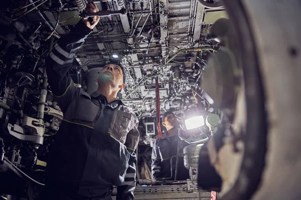 Letecký dělník opravuje letadlo v interiéru — Stock fotografie