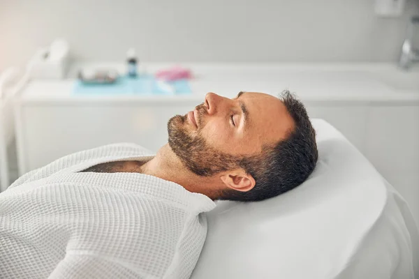 Bonito jovem descansando na clínica cosmetológica — Fotografia de Stock