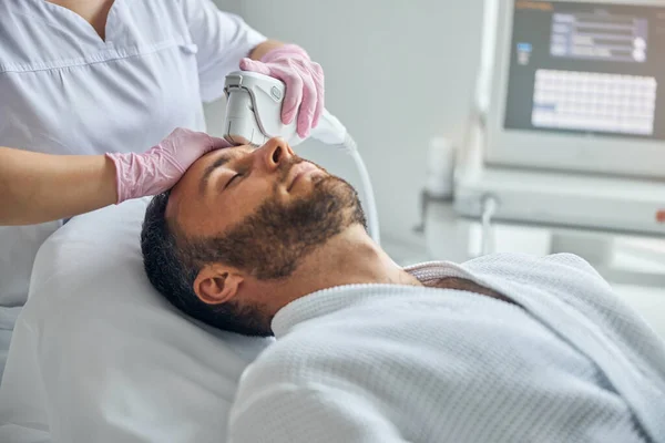 Doctor beautician treating male skin with laser device — Stock Photo, Image