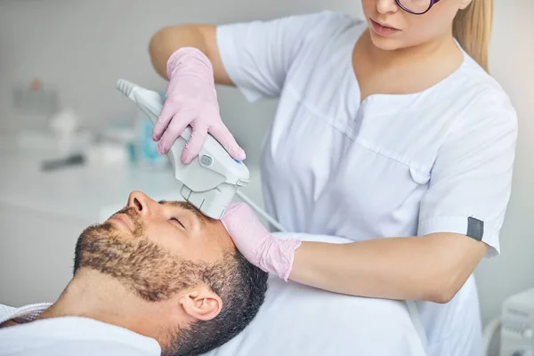 Bearded young man receiving laser facial treatment — Stock Photo, Image