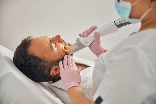 Estetista in guanti sterili che eseguono la procedura di depilazione laser — Foto Stock