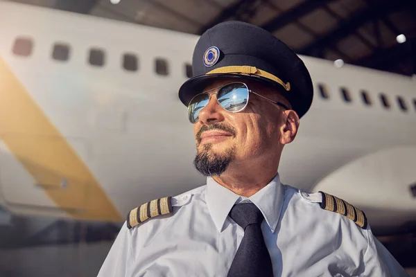 Brodaty przystojny mężczyzna w kapeluszu pilotów patrząc na słoneczne niebo — Zdjęcie stockowe