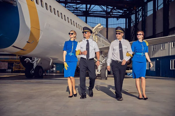 Két stewardess és pilóta együtt mennek a reptérre. — Stock Fotó