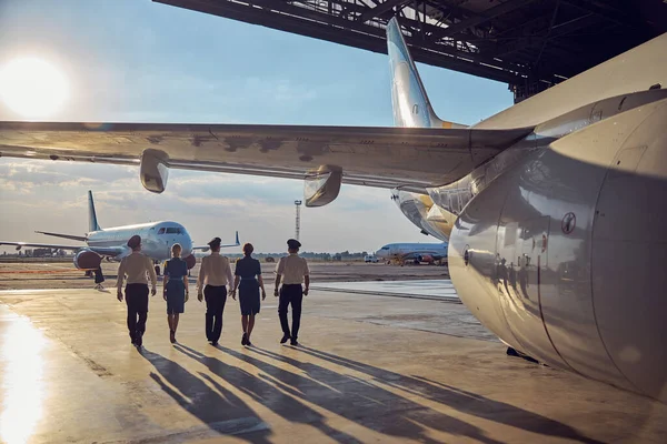 View of flight staff in the airport isolated on the sun and aircraft — Stock Photo, Image