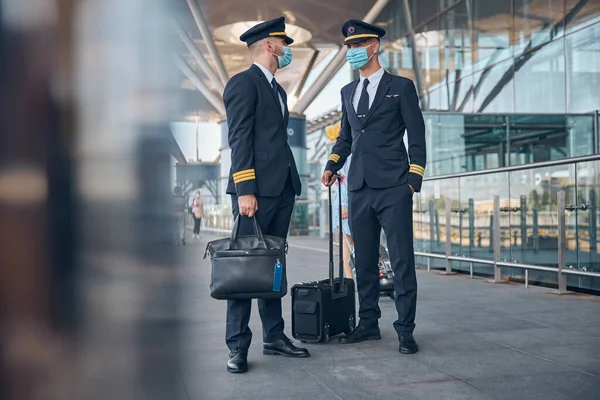 Mannelijke piloten met medische maskers op straat — Stockfoto