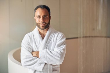 Sağlık merkezinde duran neşeli genç adam.