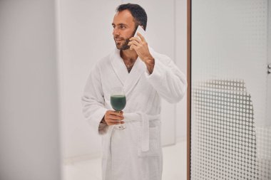 Kaplıca salonunda telefon görüşmesi yapan yakışıklı genç adam.