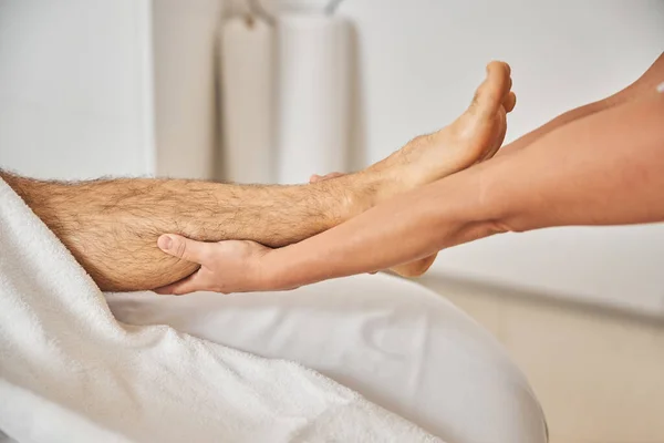 Ung man som får professionell fotmassage i spa salong — Stockfoto