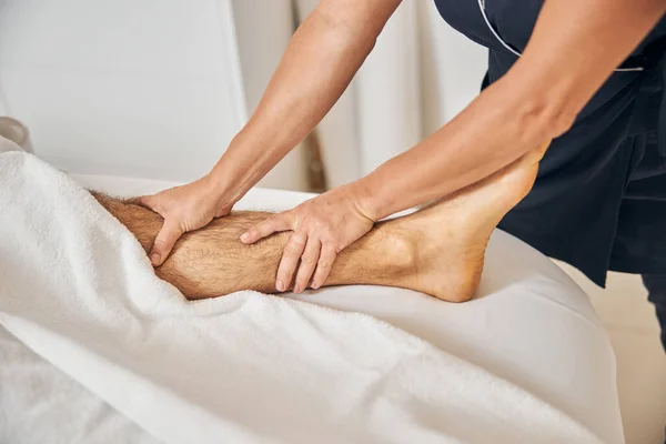 Cliente maschio che riceve massaggio ai piedi professionale nel salone spa — Foto Stock