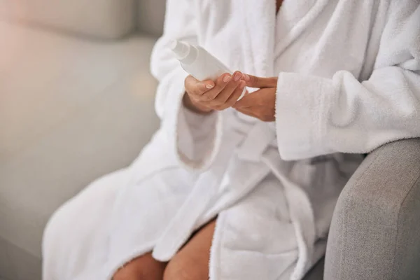 Junge Frau hält Flasche mit feuchtigkeitsspendender Lotion — Stockfoto